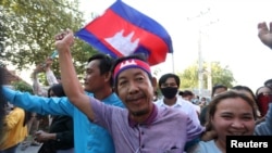 Rong Chhun, an environment activist, waves a Cambodian national flag after being released from the Correctional center in Phnom Penh, Cambodia, on November 12, 2021. (LICADHO/Raksmey Sok Handout via REUTERS)