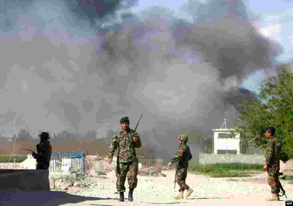 Soldiers from the Afghan National Army near the Provincial Reconstruction Team as smoke rises from the site of an attack in Jalalabad, April 15, 2012. (Reuters)