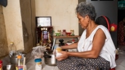 Luy Sary makes a sauce in her house for her food business in Wat Broyuvong pagoda, in Phnom Penh, Cambodia, on Tuesday, March 31, 2020. (Malis Tum/VOA Khmer)