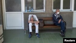 Ljudi za koje se sumnja da su oboleli od koronavirusa čekaju ispred ulaza u Kliniku za tropske i infektivne bolesti u Beogradu, 26. juna 2020. (Foto: Reuters/Marko Đurica)
