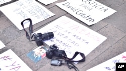 FILE - Cameras are placed over a placard reading "You don't kill the truth killing journalists" during a protest following the murder of photojournalist Daniel Esqueda in San Luis Potosi, Mexico, Oct. 6, 2017. Ten journalists were killed for their work in 2017.