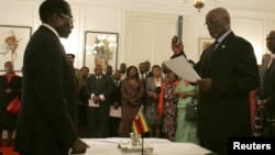 Zimbabwe President Robert Mugabe swearing in then-Vice President John Nkomo, Harare, Dec. 14, 2009. (File Photo)