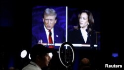 ARCHIVO - Miembros de los medios de comunicación usan una pantalla para ver el debate presidencial entre el expresidente republicano Donald Trump y la vicepresidenta demócrata Kamala Harris en Filadelfia, Pensilvania, EEUU, el 10 de septiembre de 2024