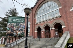 FILE - A Dartmouth Athletics banner hangs outside Alumni Gymnasium on the Dartmouth University campus in Hanover, N.H., March 5, 2024. (AP Photo/Jimmy Golen, File)