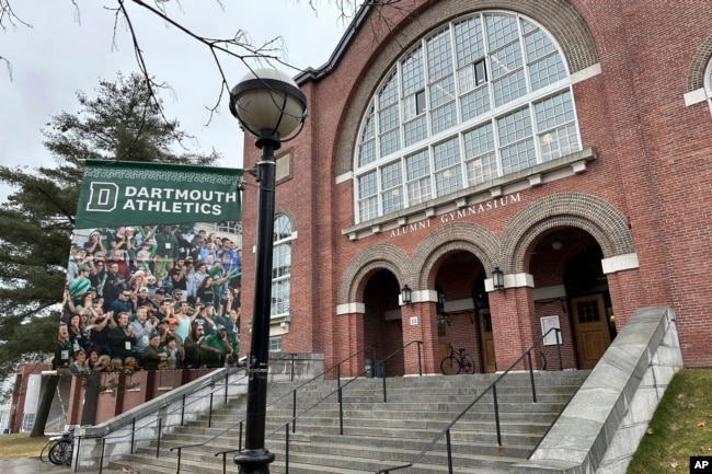 FILE - A Dartmouth Athletics banner hangs outside Alumni Gymnasium on the Dartmouth University campus in Hanover, N.H., March 5, 2024. (AP Photo/Jimmy Golen, File)