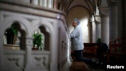 FILE - A woman prays at Sheshan Cathedral in the outskirts of Shanghai, October 28, 2013.