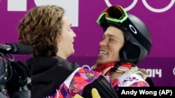 Switzerland's Iouri Podladtchikov (l) celebrates with Shaun White of the United States after Podladtchikov won the gold medal in the men's snowboard halfpipe final in Sochi, Feb 11, 2014.