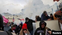 Para pendukung Presiden Donald Trump bentrok dengan polisi di depan Gedung Capitol, Washington, memprotes pengesahan hasil pilpres, 6 Januari 2021.