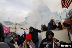 FILE - Supporters of then-President Donald Trump clash with police officers in front of the U.S. Capitol Building in Washington, January 6, 2021.