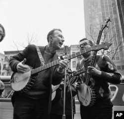 FILE - Folk singer Pete Seeger, left, performing at the Rally for Détente at Carnegie Hall in New York, May 13, 1975.