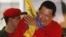 Venezuelan President Hugo Chavez hugs the national flag while celebrating from a balcony at the Miraflores Palace in Caracas, October 7, 2012. 