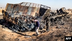 FILE - Syrians look for metal and unexploded ammunition at the site of the previous evening's Israeli airstrike that targeted shipments of weapons that belonged to Syrian government forces in Qamishli, in mainly Kurdish northeastern Syria, on Dec. 10, 2024.