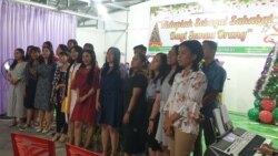 Kelompok remaja jemaat Patmos Jono’oge Gereja Protestan Indonesia Donggala di Sidera Kabupaten Sigi, menyanyikan lagu pujian natal dalam ibadah malam Natal (24/12) (VOA/Yoanes).