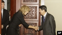 U.N. Under Secretary-General for Legal Affairs, Patricia O'Brien, center, shakes hands with Cambodian Deputy Prime Minister Sok An prior to a meeting in Phnom Penh, Cambodia, Thursday, Oct. 20, 2011. O'Brien was expected to meet with Cambodian government 