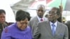 Zimbabwean President Robert Mugabe (R) is greeted by Vice President Joice Mujuru (L) after a trip to Singapore that had ignited speculation the veteran leader was seriously ill, as he returns home to Harare, Zimbabwe, April 12, 2012.