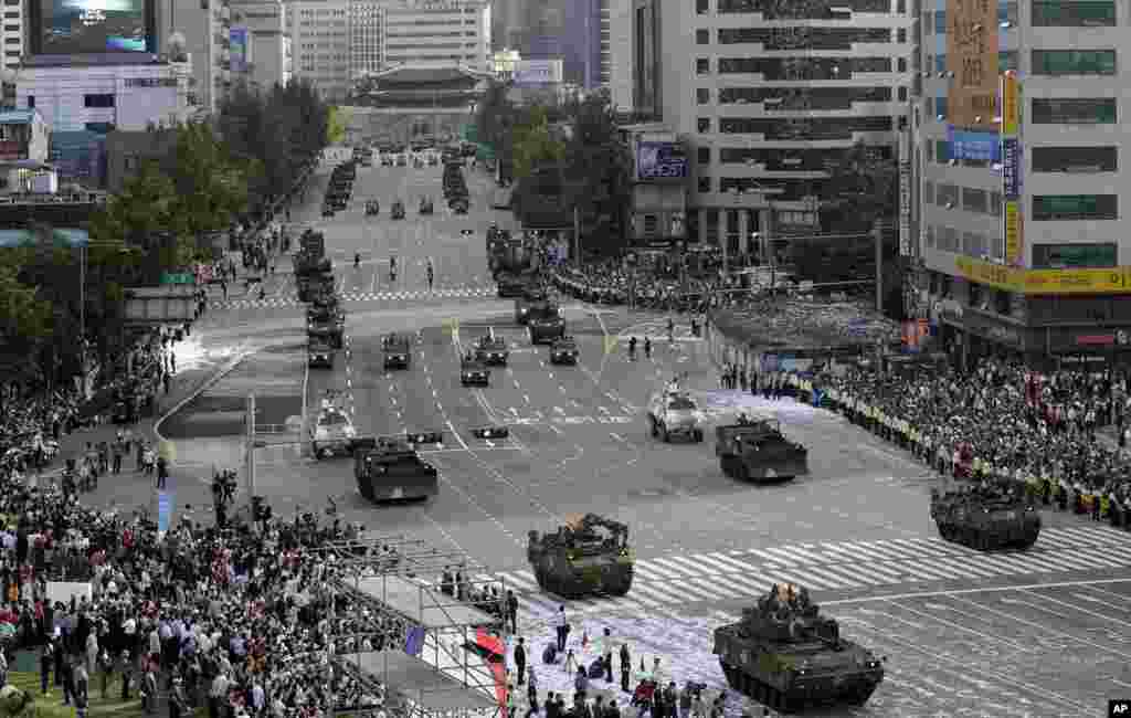 Heavy armored vehicles parade on a street with Sungnyemun Gate in the background during a parade marking the 65th anniversary of the Armed Forces Day in Seoul, Oct. 1, 2013.