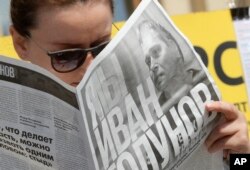 A supporter of Ivan Golunov, an investigative journalist who worked for the independent website Meduza, reads a newspaper with texts of his investigations during a protest rally in St.Petersburg, June 12, 2019.