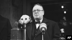 FILE - Winston Churchill approaches microphones to make a speech in January 1939. 