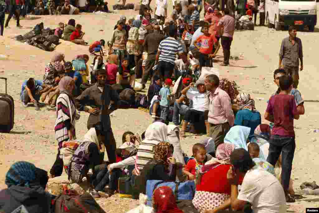 Para pengungsi Suriah menunggu melintasi perbatasan menuju daerah otonom Kurdi di Irak utara (21/8). Pemerintah Kurdistan membatasi kuota 3.000 orang sehari untuk membatasi arus pengungsi. 