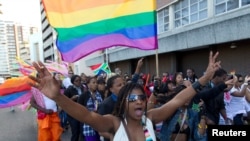 FILE - A woman holds her hands up during the Durban Pride parade where several hundred people marched through the Durban city centre in support of gay rights.