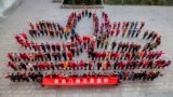 Teachers and students stand in a lotus flower formation to mark the 15th anniversary of the return of the Macau Special Administrative Region to China at a primary school in Lianyungang, east China's Jiangsu province, Dec. 19, 2014.