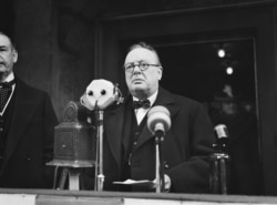 FILE - Winston Churchill approaches microphones to make a speech in January 1939.