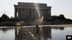 Một bé gái chạy ngang 1 vòi phun nước gần Đài tưởng niệm Lincoln ở Washington, 2/7/2012 