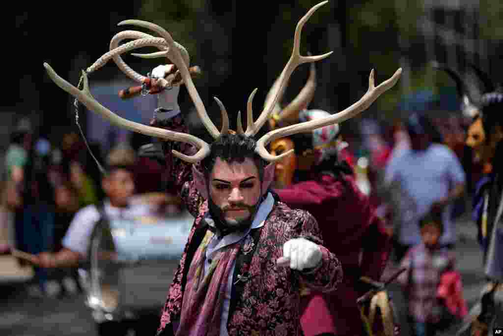 A costumed Indigenous man dances during a march in recognition of the International Day of the World&#39;s Indigenous Peoples, in Mexico City, Aug. 9, 2021.