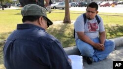 FILE - In this Oct. 5, 2017 photo, Guillermo Miranda Vazquez, right, speaks to Francisco Pacheco, left, an organizer surveying day laborers about their work conditions in Houston.