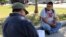 FILE - In this Oct. 5, 2017 photo, Guillermo Miranda Vazquez, right, speaks to Francisco Pacheco, left, an organizer surveying day laborers about their work conditions in Houston.