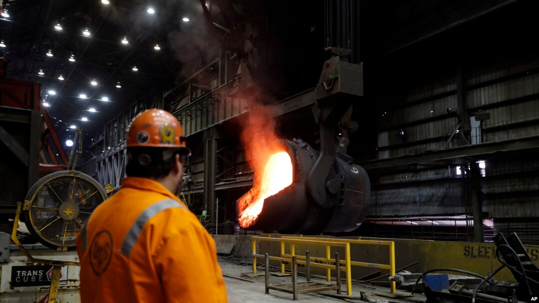 FILE- Senior melt operator Randy Feltmeyer watches a giant ladle backing away after pouring its contents of red-hot iron into a vessel in the basic oxygen furnace as part of the process of producing steel at the U.S. Steel Granite City Works facility in Granite City, Ill., June 28, 2018,
