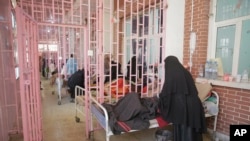 FILE - Women are treated for suspected cholera infection at Al-Sabeen hospital, in Sanaa, Yemen, Mar. 30, 2019.