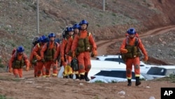 FILE - Rescuers walk into the accident site where 21 cross-country ultramarathon runners died near Baiyin, Gansu province, China, May 23, 2021. (Xinhua News Agency via AP)