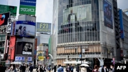 Orang-orang yang mengenakan masker di tengah kekhawatiran tentang penyebaran virus COVID-19 melintasi persimpangan Shibuya yang tenang di Tokyo pada 28 April 2020. (Foto: AFP/ Behrouz Mehri)