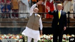 El presidente de EE.UU., Donald Trump, y el primer ministro de India, Narendra Modi, saludan a la multitud en el estadio Sardar Patel en Ahmedabad, India, el lunes, 24 de febrero de 2020.