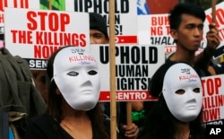 Masked protesters gather for a rally near the Presidential Palace to mark International Human Rights Day, Dec. 10, 2016, in Manila, Philippines. The protesters are calling on the government for an end to extrajudicial killings in the country, which have claimed more than 4,000 lives.