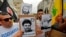 Protesters carry signs showing the faces of Lebanee Shiite movement Hezbollah leader Hassan Nasrallah and slain military commander Mustafa Badreddine as they march in an anti-US demonstration near US Embassy headquarters in Akwar, July 10, 2020. 