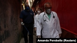 Personnel soignants traversant un grand quartier populaire de Paraisopolis, où les résidents ont embauché un service médical privé, Sao Paulo, Brésil 39 mars 2020. (Reuters/Amanda Perobelli)
