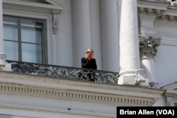European Union foreign policy chief Federica Mogherini takes a break on a balcony at the Palais Coburg hotel in Vienna, Austria, July 10, 2015.