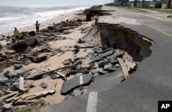 Officials photograph sections of highway A1A that were washed out by Hurricane Matthew, Oct. 8, 2016, in Flagler Beach, Florida.