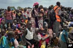 FILE - Men, women and children line up to be registered with the World Food Program for food distribution in Old Fangak, in Jonglei state, one of the worst affected areas for food insecurity in South Sudan, June 17, 2017.