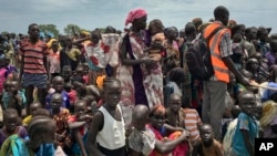 Men, women and children line up to be registered with the World Food Program for food distribution in Old Fangak in South Sudan. 