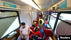 A man receives a dose of the coronavirus disease (COVID-19) vaccine at the "Vaccination-Express" (Impfexpress) train touring through the city in Frankfurt, Germany, Oct. 25, 2021.