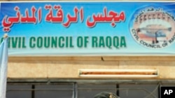 FILE - A sign for the Civil Council of Raqqa is seen on a building in Ain Issa on the northern outskirts of the former self-proclaimed Islamic State capital in Syria, July 23, 2017.