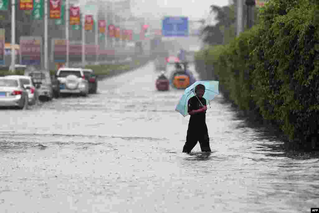 A man walks on a flooded street as typhoon Matmo made landfall,&nbsp;Jinjiang, Fujian province, China, July 23, 2014.