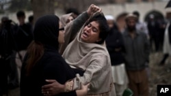 A grieving woman is comforted outside a hospital morgue, where the bodies of victims of a twin suicide bombing were taken, Islamabad, March 3, 2014. 