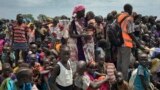 In this photo taken June 17, 2017, men, women and children line up to be registered with the World Food Program for food distribution in Old Fangak, in Jonglei state, one of the worst affected areas for food insecurity in South Sudan. 