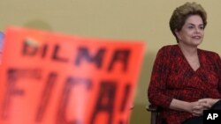 Brazil’s President Dilma Rousseff attends having in front a poster written in Portuguese "Dilma Stay, during ceremony of the Launch Program New Federal Universities, at the Planalto Presidential Palace, in Brasilia, May 9, 2016.