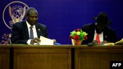 President of South Sudan, Salva Kiir (R) and South Sudan rebel leader Riek Machar sign a final power-sharing deal between arch-foes, Aug. 5, 2018, in Khartoum. 