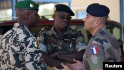 A French army officer (R) talks to his Malian and Senegalese army counterparts outside where a meeting is taking place for the intervention force provided by the ECOWAS grouping of West African states, in Bamako January 15, 2013.